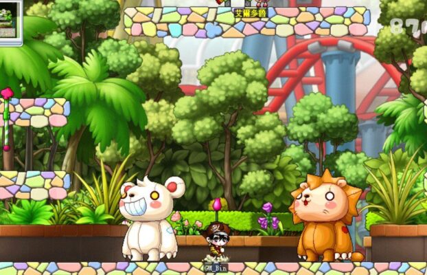 這張來自《楓之谷》（MapleStory）的遊戲畫面，展示了艾麗多樂園（Ellinia Theme Park）內部的場景。背景有熱帶森林與紅色雲霄飛車軌道，營造出遊樂園氛圍。畫面中央的玩家「GM_Bin」站在地面上，周圍有兩隻巨大可愛的怪物：左側是露出誇張微笑的白色熊怪，右側是表情呆萌的橙色獅子怪。整體畫面色彩繽紛，呈現童話般的奇幻風格。